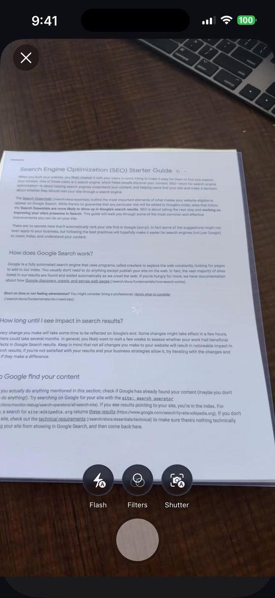 FileSway's document scanner on iPhone: a printed page on a desk, outlined in blue where FileSway found its edges, with Flash, Filters and Shutter controls below.